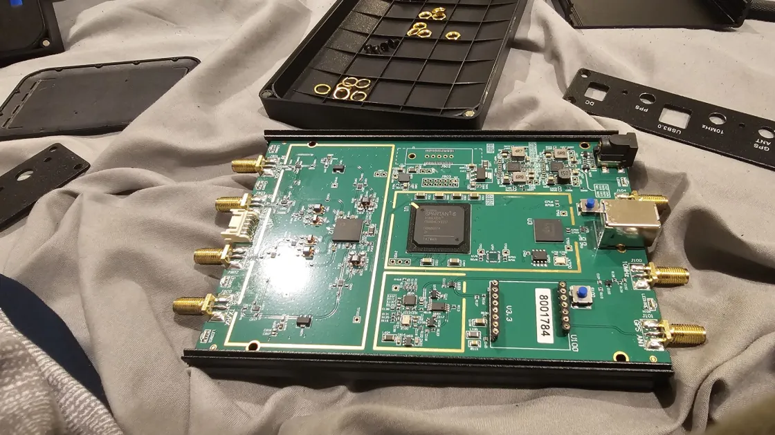 An opened USRP B210 software-defined radio board, showing its Spartan-6 FPGA and SMA antenna connectors.